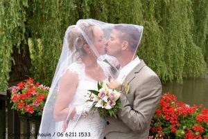 Couple s'embrassant sous le voile de la mariée