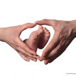 Couple, mains en forme de coeur et pieds de bébé